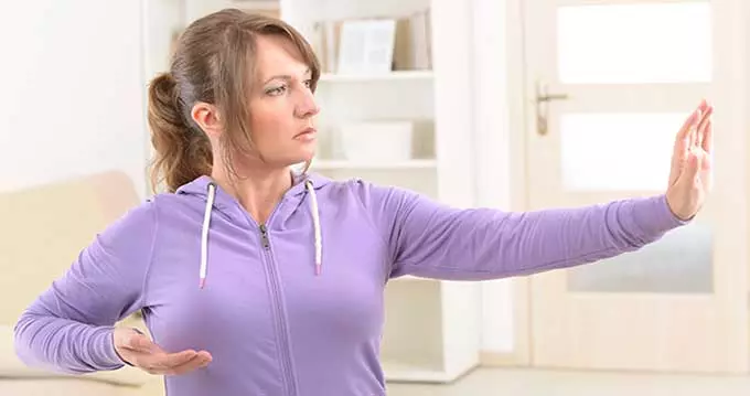 женщина делает упражнение цигун